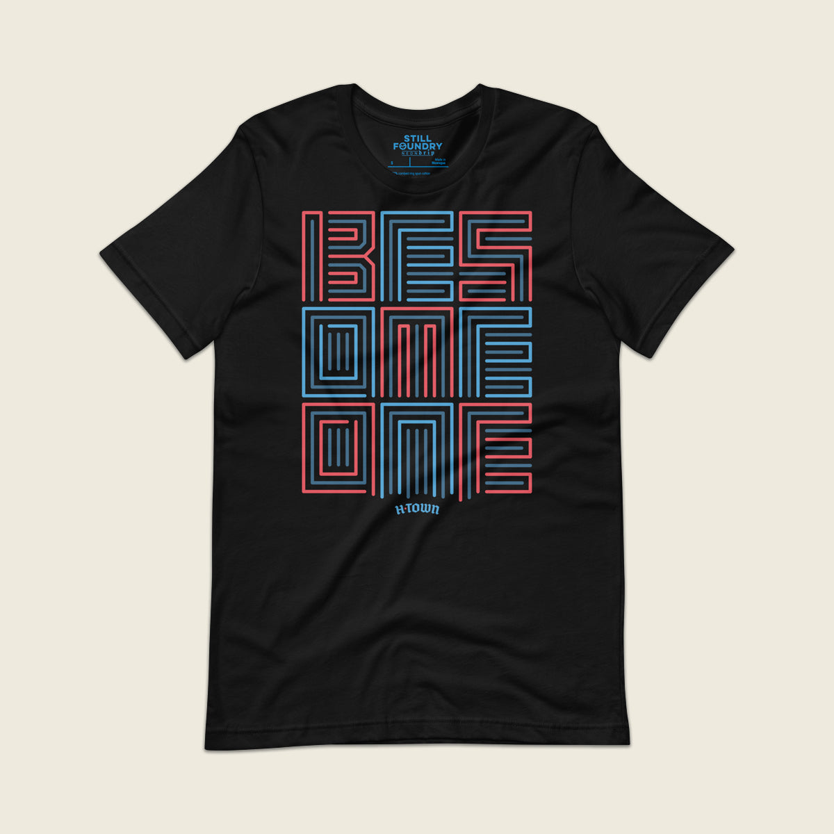 Black t-shirt featuring a bold geometric typographic design that reads “BE SOMEONE” in stacked red and blue outlined lettering, with small text below that reads “H-town.”