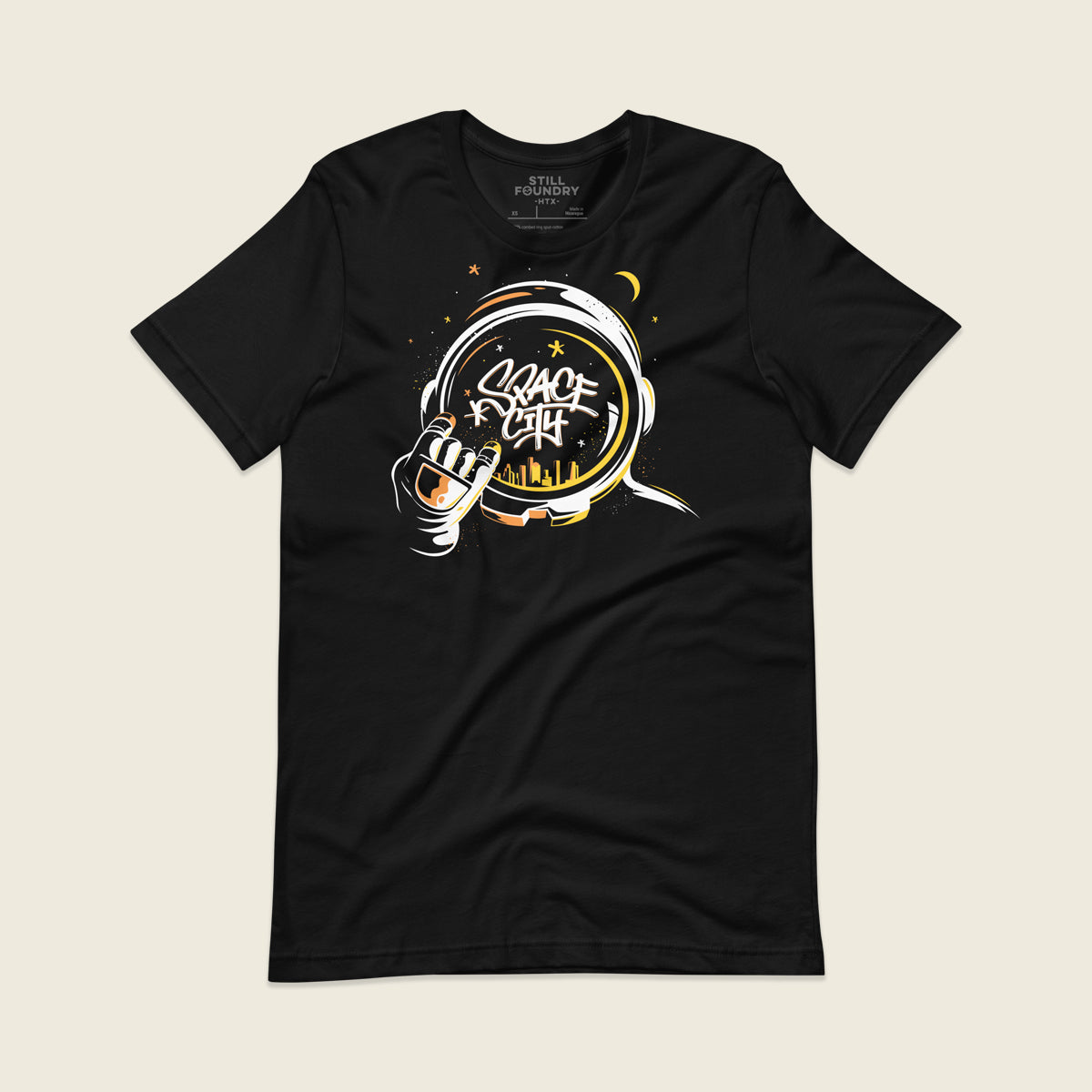 Black t-shirt featuring an illustrated astronaut holding up the H-Town hand sign, with the word “Space City” written in graffiti-style lettering inside the astronaut’s helmet and a yellow Houston skyline reflected below, surrounded by stars and a crescent moon.