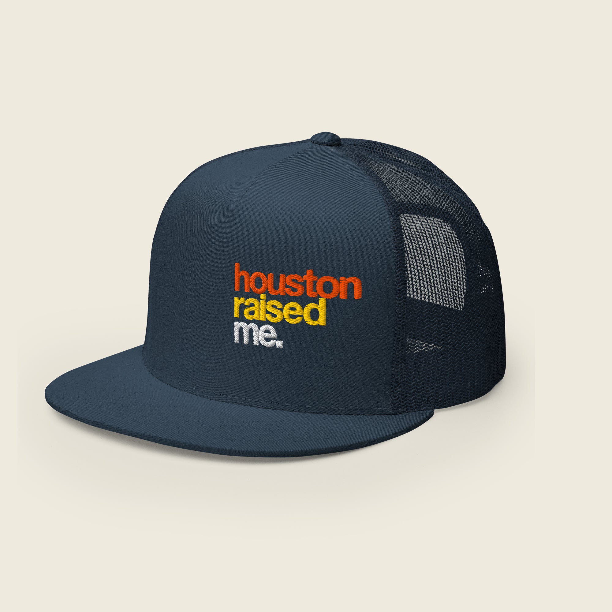 Navy trucker snapback hat, front panel and flat bill visible; embroidered, stacked text at right-front reads “houston” (orange), “raised” (yellow), “me.” (white).