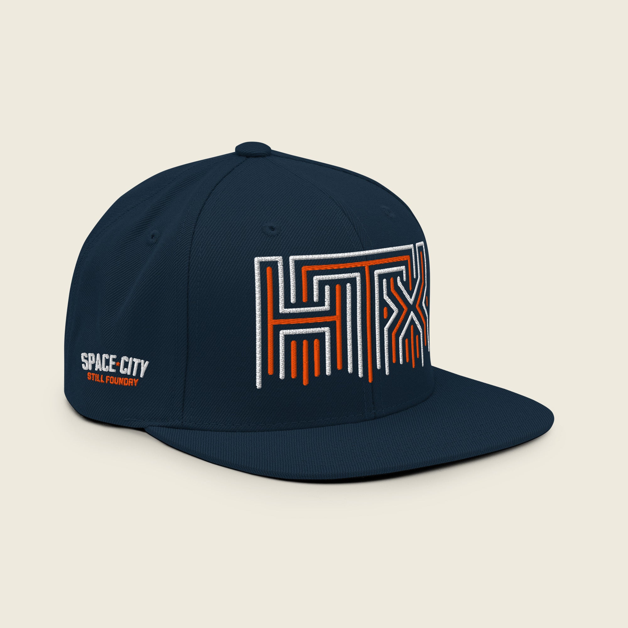 Angled view of navy HTX Houston snapback hat with bold embroidered logo and flat brim.