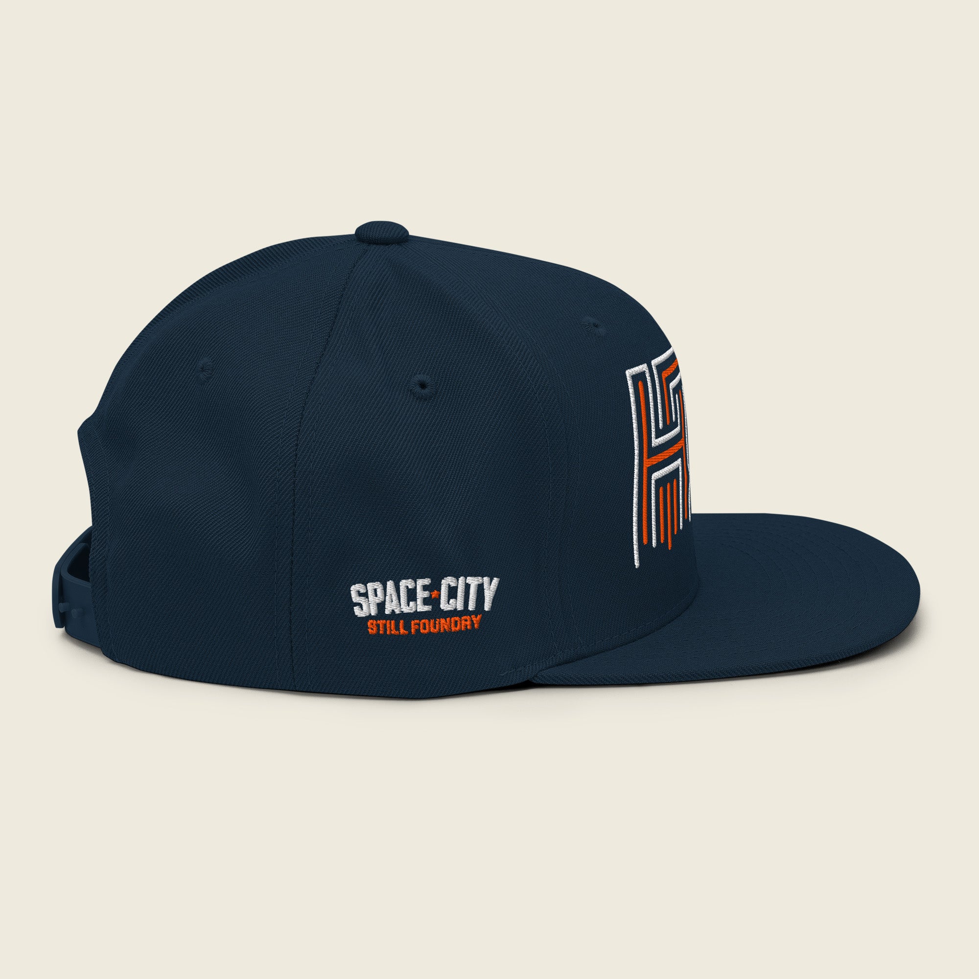 Side view of navy Houston snapback hat with Space City Still Foundry embroidery detail.