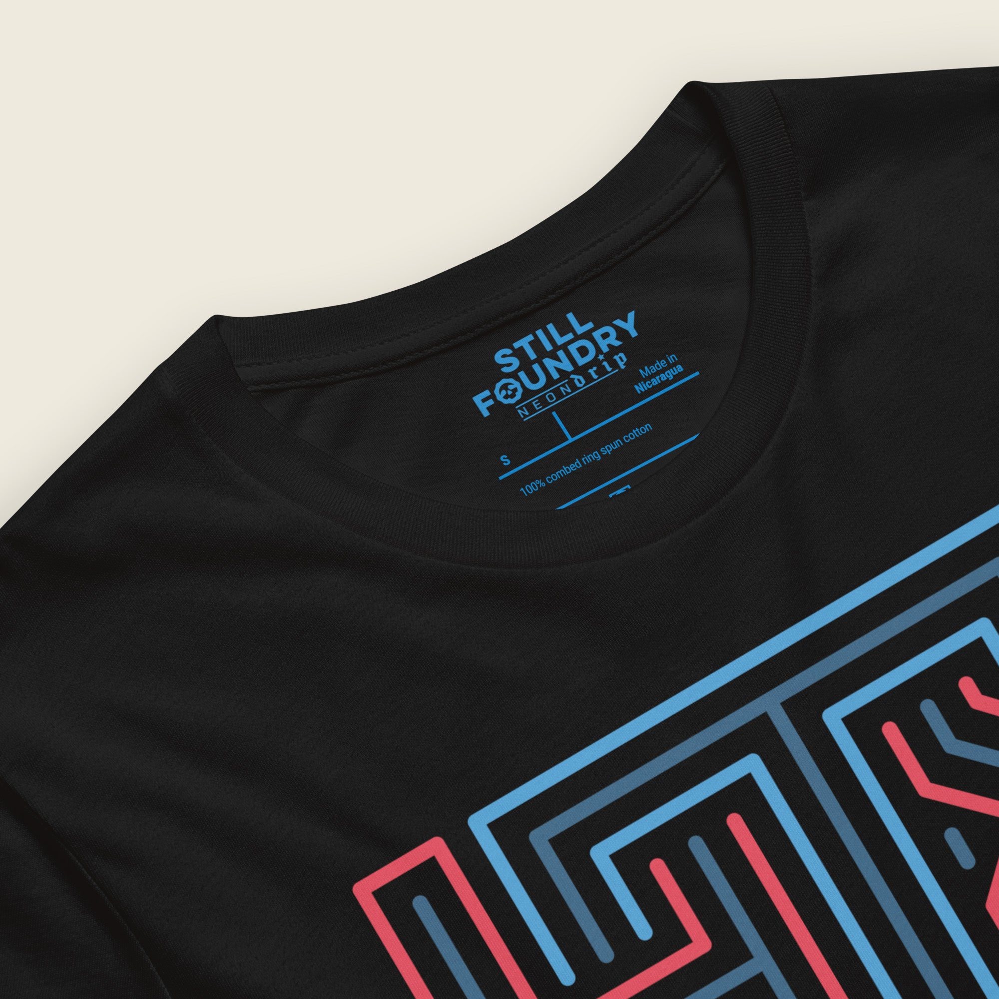 Close up of black short-sleeve t-shirt laid flat with a large geometric neon sign “HTX” graphic in red and blue on the chest 