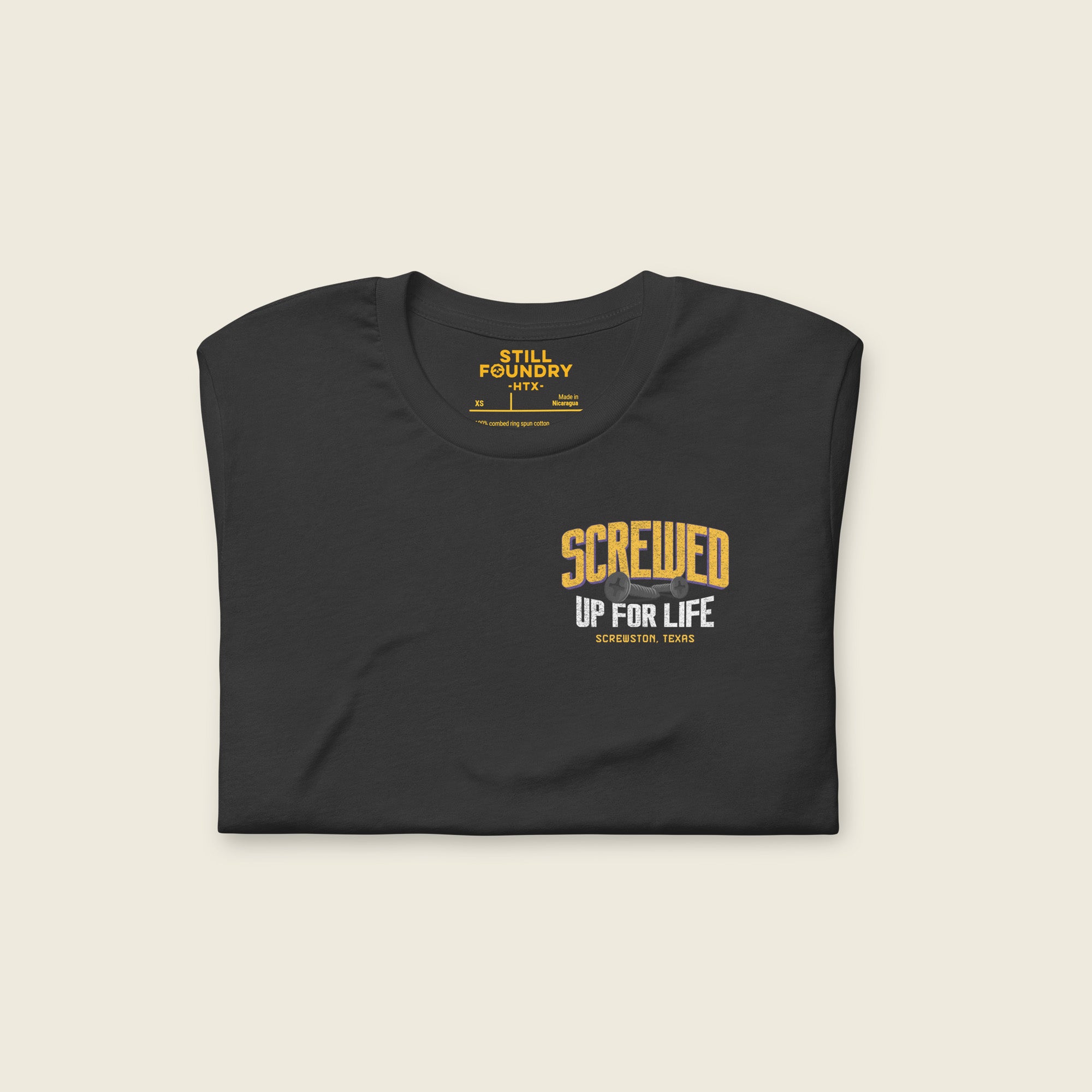 Folded front of dark gray Houston streetwear T-shirt with small “Screwed Up For Life – Screwtown Texas” chest graphic.